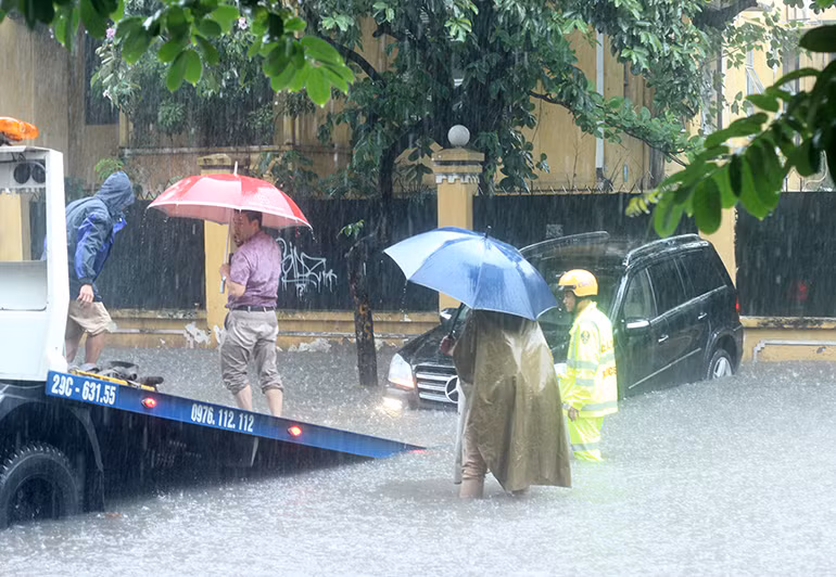 Nhiều xe ô tô bị nước ngập làm chết máy phải nhờ đến xe cứu hộ.