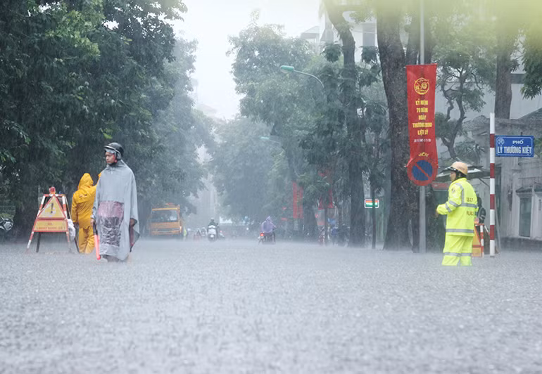Nước ngập mênh mông ở ngã tư Lý Thường Kiệt - Phan Bội Châu. Lực lượng CSGT, các công nhân Công ty TNHH MTV Thoát nước Hà Nội túc trực, phân luồng, điều tiết giao thông, tránh để các phương tiện di chuyển vào khu vực nước ngập.