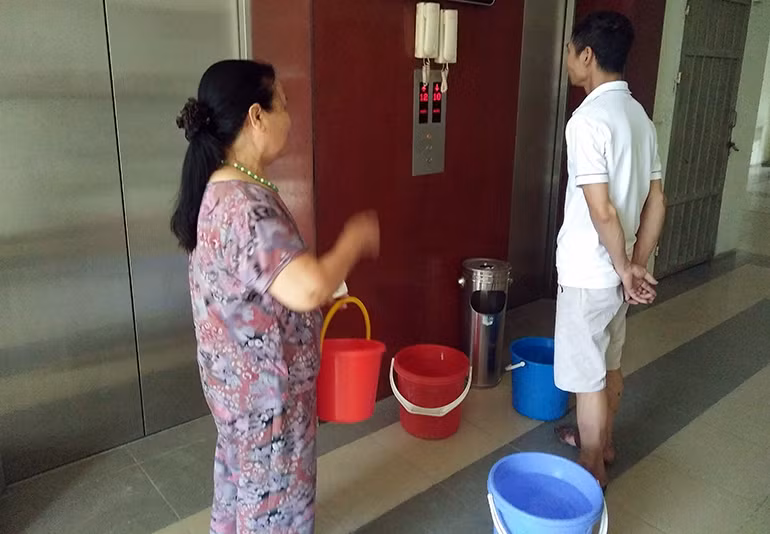 Người dân phải xách từng xô nước sạch ít ỏi từ bể nước dưới sân lên nhà.