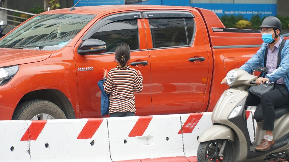 "Hỏi gì nhiều thế, không mua hàng thì đi chỗ khác, đứng đây để làm gì. Sau nhiều lần đi qua đây, tôi quan sát vẫn thấy người đàn ông kia, hôm thì người này dựng xe ở ngay chân cầu đường vành đai 3 trên cao, hôm thì đứng trên vỉa hè đoạn lối rẽ từ đường Dương Đình Nghệ ra đường Phạm Hùng. Dù ở vị trí nào, thì người này vẫn hướng đôi mắt về những người bán hàng rong". 