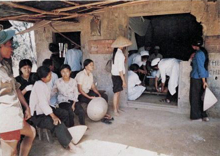 Bà con nông dân trong thôn lo lắng đứng ngoài theo dõi việc chữa chạy cho người phụ nữ xấu số.