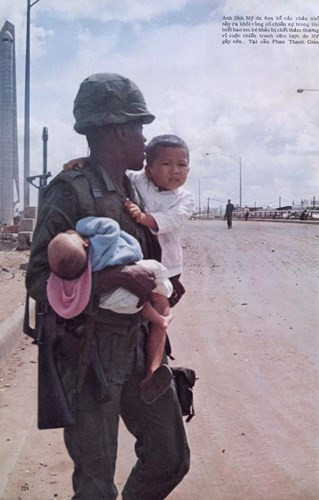 Một lính Mỹ da đen bế các cháu nhỏ ra khỏi vùng chiến sự.