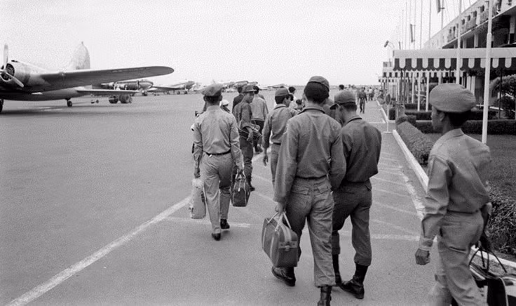 Hành khách mới hạ cánh xuống sân bay đi bộ vào nhà ga.