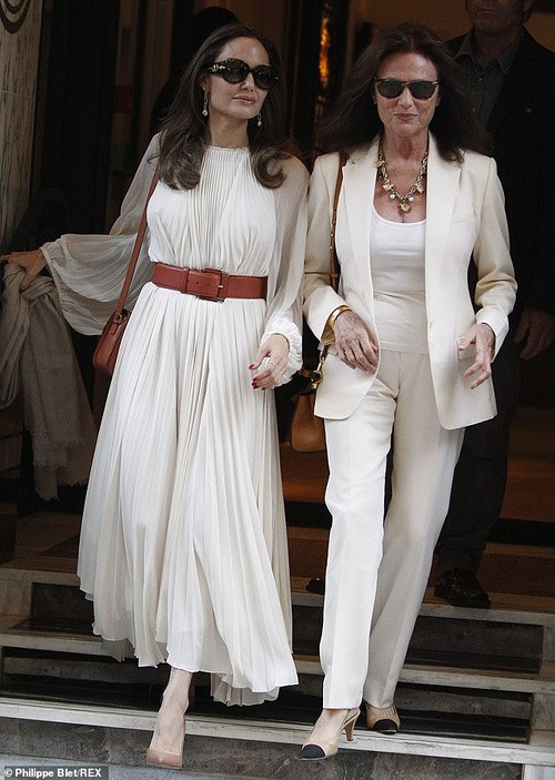 Hai ngôi sao diện đồ "ton sur ton" màu trắng. Nếu bà Bisset mặc vest hiện đại, cá tính, Angelina lại chọn cho mình bộ đầm xếp ly dài kín bưng.