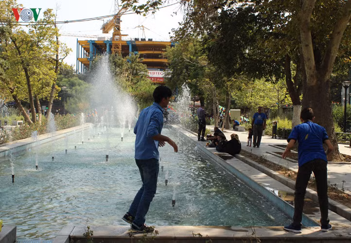 Mùa hè nóng, mọi người tìm đến các công viên có đài phun nước.