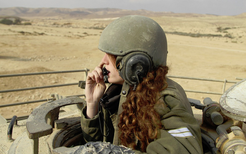 Hình ảnh ấn tượng về một bóng hồng ngồi ở tháp pháo xe tăng của quân đội Israel trên sa mạc.