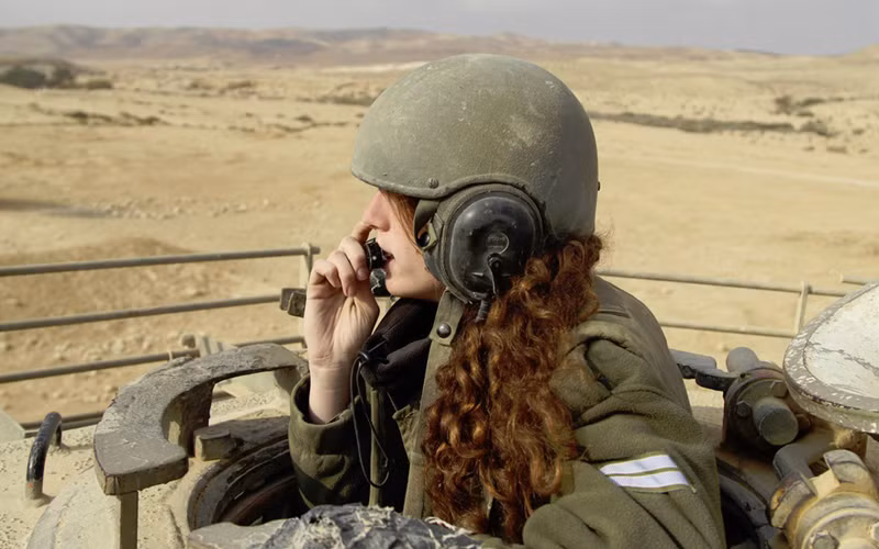 Hình ảnh ấn tượng về một bóng hồng ngồi ở tháp pháo xe tăng của quân đội Israel trên sa mạc.