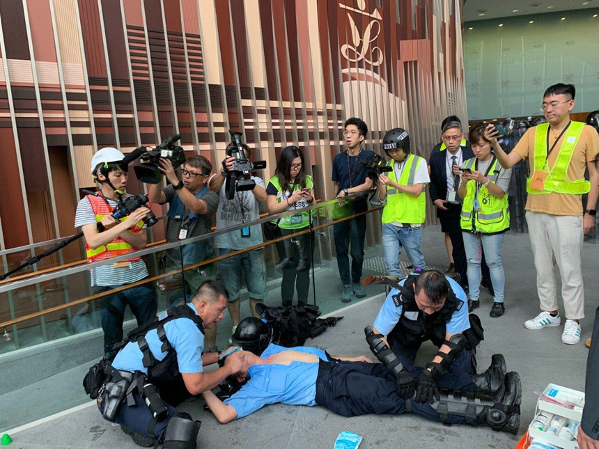 Cảnh sát bị thương đang được các đồng nghiệp chăm sóc. Ảnh: SCMP. *) Title do Kiến Thức biên tập lại