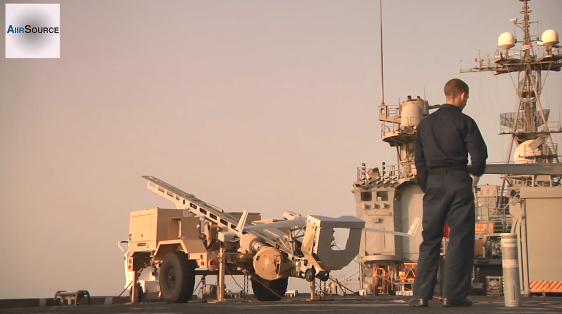 Một hệ thống ScanEagle sẽ bao gồm 4 thiết bị khác nhau, bao gồm 1 trạm điều khiển dưới mặt đất, một bàn điều khiển từ xa bằng hình ảnh cùng các hệ thống phóng và hệ thống thu hồi. Mỗi chiếc UAV ScanEagle đều được trang bị camera điện-quang học và/hoặc camera hồng ngoại, lắp đặt trên hệ thống tháp quán tính ổn định. Hình ảnh UAV ScanEagle được triển khai từ bệ phóng di động trên tàu chiến Mỹ. Nguồn ảnh: AiirSource Military