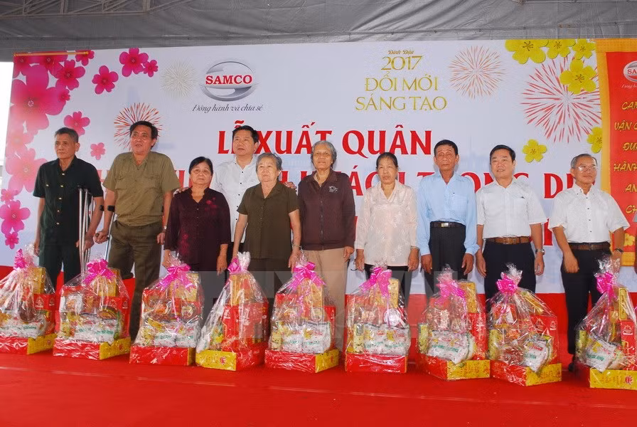 Bí thư Thành ủy Đinh La Thăng tặng quà cho các gia đình chính sách quận Bình Tân tại Bến xe Miền Tây. (Ảnh: Mạnh Linh-TTXVN)