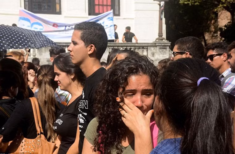 Một bạn sinh viên đại học mắt đỏ hoe khi cùng bạn bè diễu hành tới khu vực tưởng niệm lãnh tụ Cuba Fidel Castro ở La Habana ngày 26/11/2016. Ảnh Daily Mail