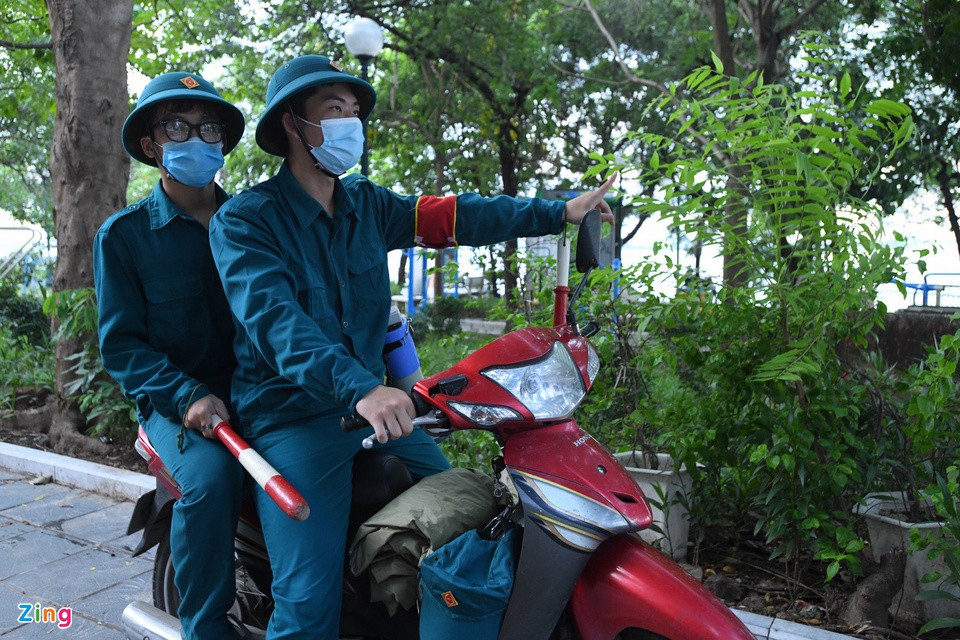 Anh Bách và anh Minh, lực lượng dân quân tự vệ phường Thuỵ Khuê, có mặt tại khu thể thao ngoài trời trên phố Nguyễn Đình Thi thực hiện nhiệm vụ. Anh cho biết hầu hết người dân đều chấp hành nghiêm chỉnh sau khi được nhắc nhở. Tuy nhiên, vẫn có những người thắc mắc về thông báo mới, nhưng sau khi được giải thích, họ vui vẻ ra về.