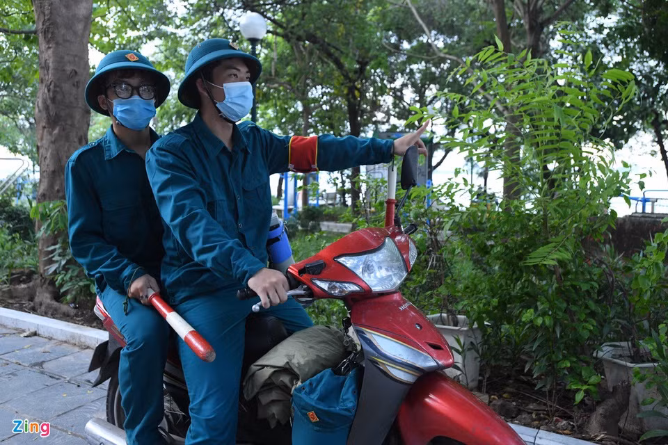 Anh Bách và anh Minh, lực lượng dân quân tự vệ phường Thuỵ Khuê, có mặt tại khu thể thao ngoài trời trên phố Nguyễn Đình Thi thực hiện nhiệm vụ. Anh cho biết hầu hết người dân đều chấp hành nghiêm chỉnh sau khi được nhắc nhở. Tuy nhiên, vẫn có những người thắc mắc về thông báo mới, nhưng sau khi được giải thích, họ vui vẻ ra về.