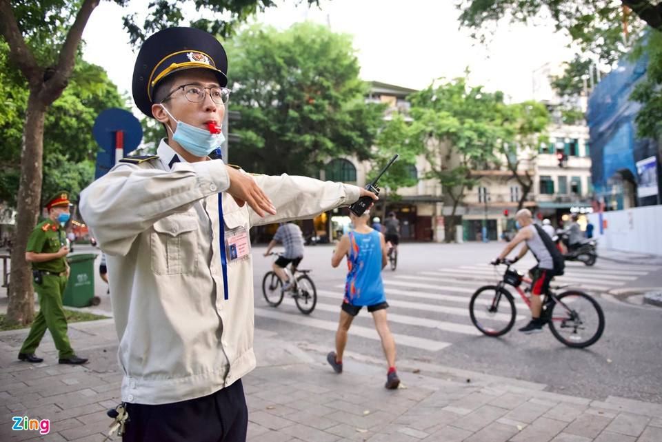 Xung quanh hồ Gươm, công an, dân phòng làm nhiệm vụ nhắc nhở những người đang đạp xe, chạy bộ hãy trở về nhà.