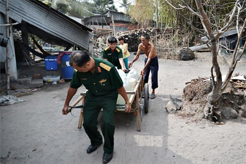 Các chiến sĩ hỗ trợ người dân chuyển nước về nhà.