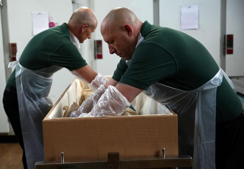 Nhân viên Stuart Emans và Graham Cowper làm việc trong nhà xác ở London ngày 4/5.