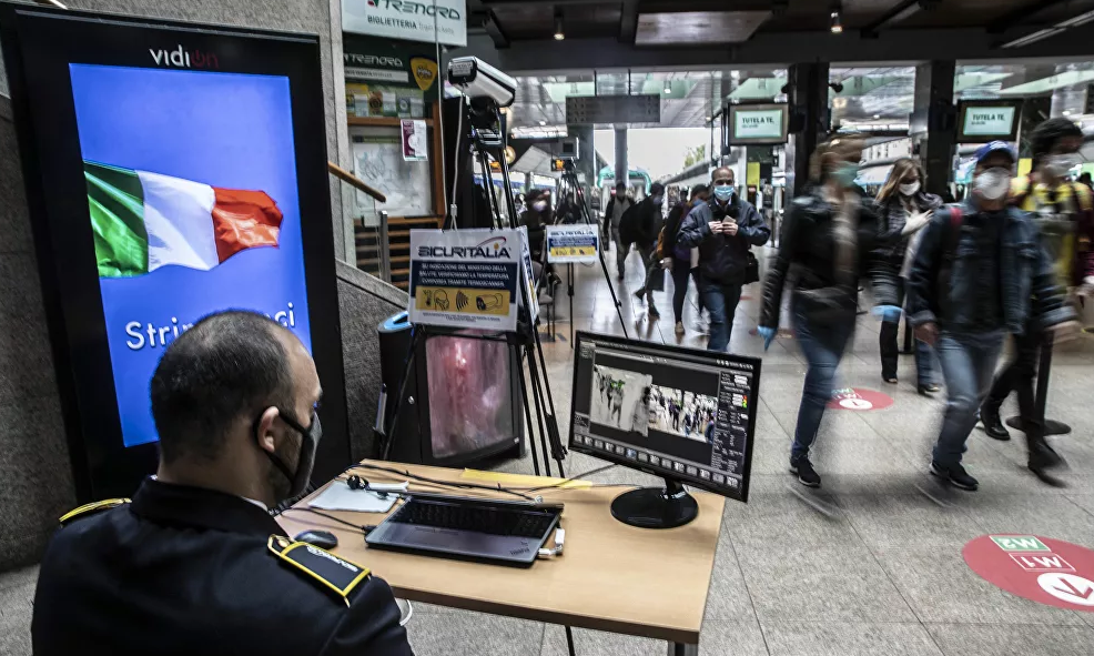 Nhân viên an ninh theo dõi thân nhiệt của các hành khách tại nhà ga Cadorna ở Milan ngày 4/5.