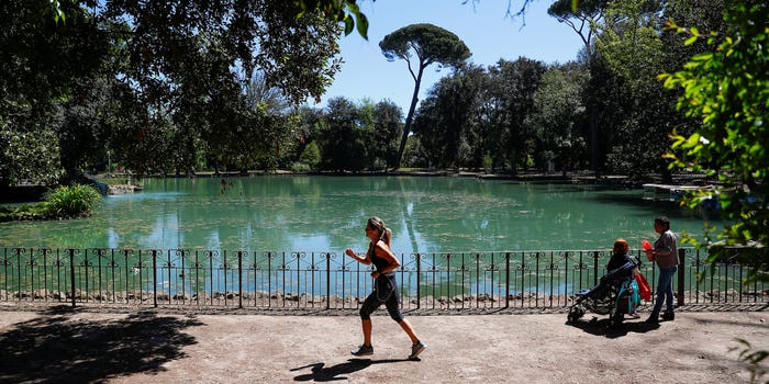 Cô gái chạy bộ trong công viên mới mở cửa trở lại ở Rome, Italy.