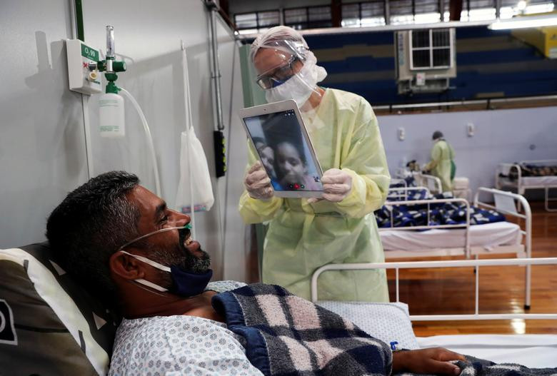 Fabiano Santana de Souza, một bệnh nhân COVID-19 37 tuổi, nói chuyện với vợ con qua cuộc gọi video khi đang được điều trị tại bệnh viện dã chiến được thiết lập trong phòng tập thể dục ở Santo Andre, Sao Paulo, ngày 6/5.
