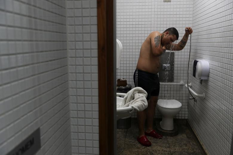 Daniel Gallo, 25 tuổi, tắm trong nhà vệ sinh tại sân bay gần Sao Paulo ngày 23/5.