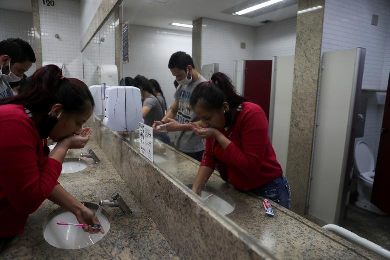 Angie Mosquera, 22 tuổi, đánh răng trong nhà vệ sinh của sân bay gần Sao Paulo hôm 25/5.