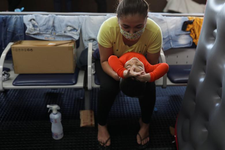 Yeraldin Betancourt, 27 tuổi, và con trai, Yeremy, 2 tuổi, ngồi chờ ở sảnh của sân bay Guarulhos ngày 25/5.