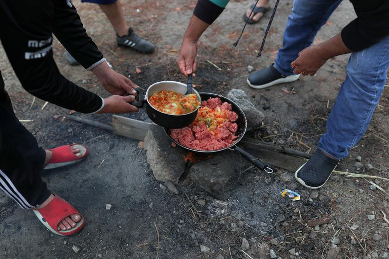 Một số người nấu ăn cho bữa trưa gần sân bay ở Guarulhos hôm 24/5.