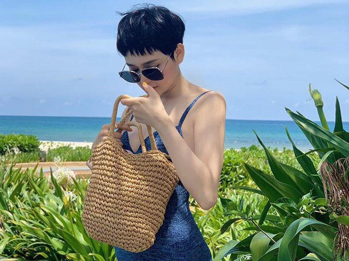 Chiếc túi cói này hẳn vượt xa mọi item hàng hiệu để dẫn đầu về độ yêu thích và được Hiền Hồ thường xuyên sử dụng. Không chỉ tiện lợi cho những chuyến đi xa, túi cói chưa bao giờ “lệch tông" cho những tấm hình biển xanh, mây trắng như thế này.