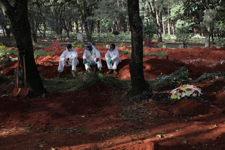 Một số công nhân đào mộ ngồi nghỉ sau ngày làm việc mệt mỏi tại nghĩa trang Vila Formosa.