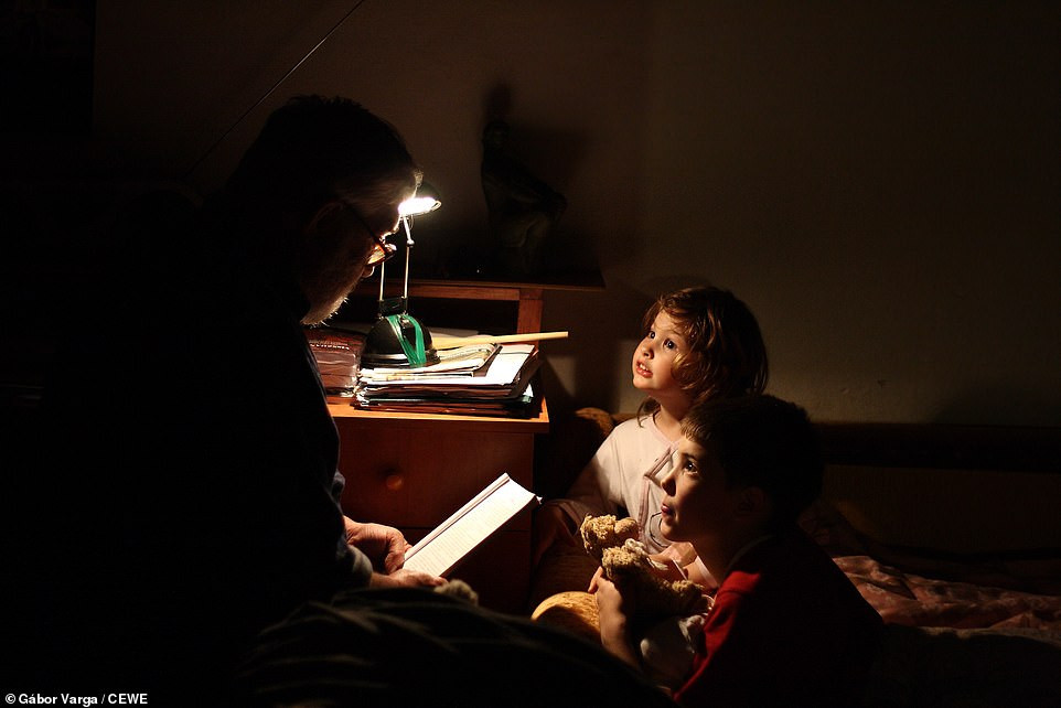 Theo Daily Mail, từ Hungary đến Tanzania, các nhiếp ảnh gia đã ghi lại những niềm vui đơn giản trong cuộc sống hàng ngày của nhiều người dân trên khắp thế giới. Ảnh: Hai đứa trẻ chăm chú nghe cha mẹ kể chuyện trước khi đi ngủ. Khoảnh khắc ấm áp này do nhiếp ảnh gia Gabor Vara ở Pecs, Hungary, ghi lại. (Nguồn ảnh: Daily Mail)