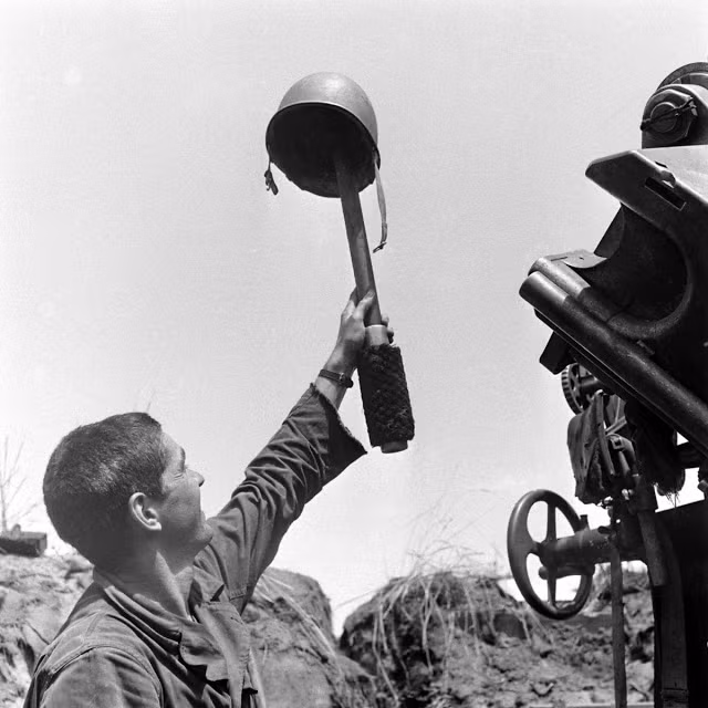 Một lính Mỹ đánh lừa lính bắn tỉa của kẻ thù bằng cách giơ cao chiếc mũ lên.