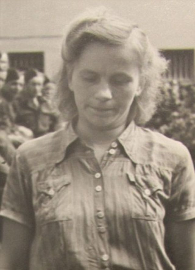 Một trong những phụ nữ làm việc tại trại tập trung của Đức quốc xã cúi gằm mặt khi bị bắt giữ.