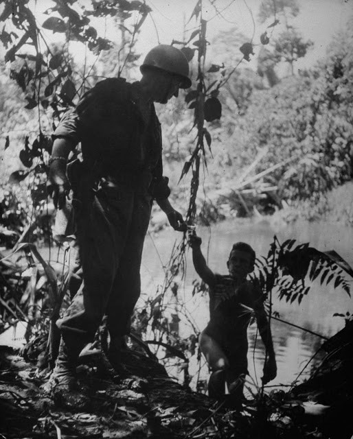 Một binh sĩ đưa cho đồng đội điếu xì gà.