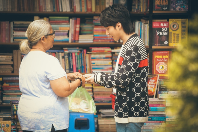 Tùng mua cuốn sách tự truyện của chính cậu bên đường.