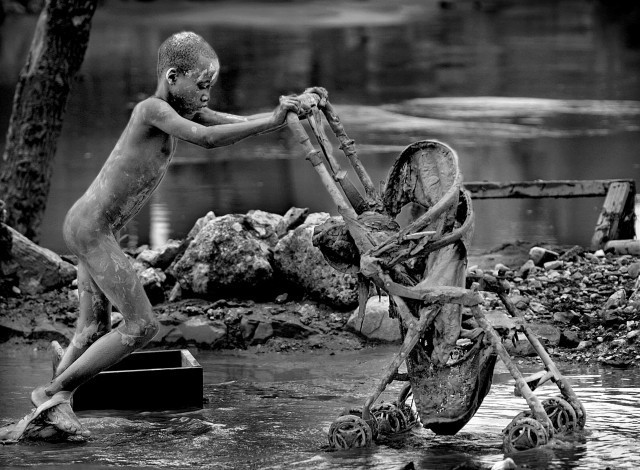 Cậu bé gồng mình đẩy chiếc xe nôi sau khi cơn bão Hanna càn quét Haiti năm 2008 gây ra thiệt hại to lớn về người và tài sản. Sau thảm kịch thiên nhiên này, cuộc sống của người dân gặp nhiều khó khăn.