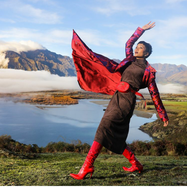 Hoa hậu H'hen Niê chọn một chiếc đầm suông dài chất liệu nhung ấm áp phù hợp với thời tiết se lạnh bên trời Tây. Bên ngoài là một chiếc áo khoác dài dày dặn in hoa văn độc đáo và nổi bật.