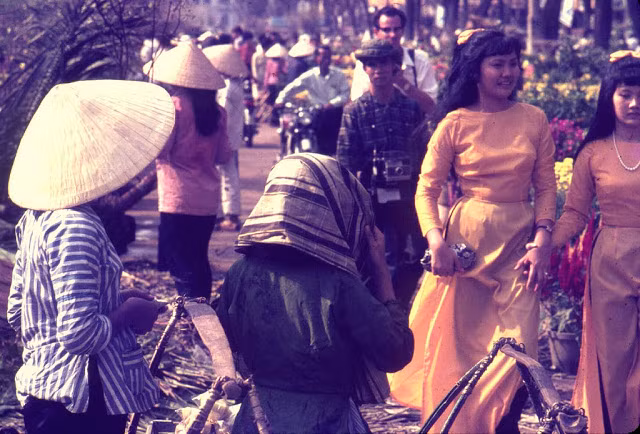 Vẻ đẹp rạng rỡ, đầy sức sống của những cô gái ở Sài Gòn trong tà áo dài trong một khu chợ.