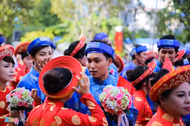 Chú rể đang sửa sang lại khăn áo cho cô dâu của mình.