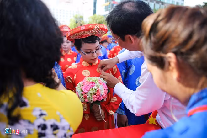 Trong ảnh, Ban tổ chức gắn huy hiệu thành phố cho đôi uyên ương.