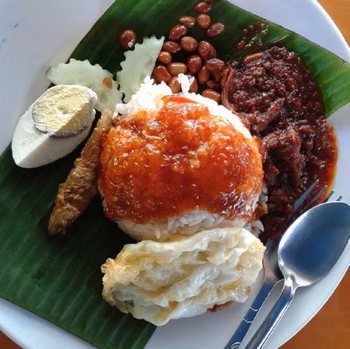 Nasi Lemak là món ăn phổ biến trong bữa sáng của người Malaysia. Cơm được nấu với nước dừa và lá dứa thơm phức. Sau đó, người ta sẽ rưới sốt đặc biệt, ăn kèm với cá cơm và dưa chuột.