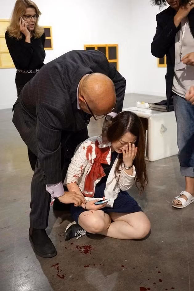 Tội ác bị tưởng nhầm là… sắp đặt nghệ thuật. Cảnh tượng ghê rợn xảy ra hồi đầu tháng 12.2015, tại triển lãm nghệ thuật Art Basel Miami Beach (Mỹ) khi một phụ nữ bị tấn công bằng dao và bị thương khá nặng, khi cô này ngã ra sàn, thậm chí… máu chảy đầm đìa, thì những người đang có mặt tại phòng triển lãm vẫn đứng yên quan sát vì tưởng lầm rằng họ đang được chứng kiến một màn nghệ thuật sắp đặt. Scandal kinh hoàng chấn động giới nghệ thuật khiến dư luận bàng hoàng, kinh sợ.