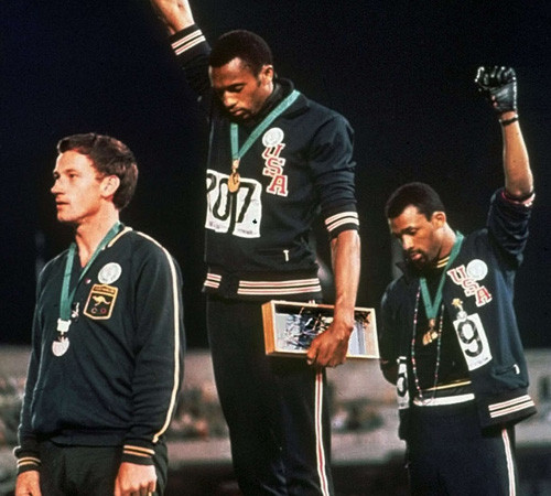 Năm 1968, 2 vận động viên điền kinh của Mỹ là Tommie Smith và John Carlos đã giơ nắm tay đeo găng tay đen khi bài quốc ca Mỹ “The Star-Spangled Banner” được phát tại Thế vận hội mùa Hè tổ chức ở Mexico. Bức ảnh này đã đi vào lịch sử thể thao thế giới khi hai vận động viên điền kinh trên muốn phát đi thông điệp về nhân quyền ngay tại một sự kiện thể thao mang tầm cỡ thế giới: người da màu cũng có quyền con người.