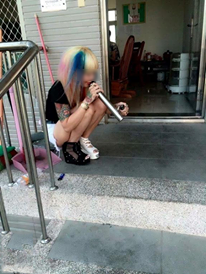 Thiếu nữ "tóc bảy màu" học đòi hút thuốc lào. Ảnh: Facebook.