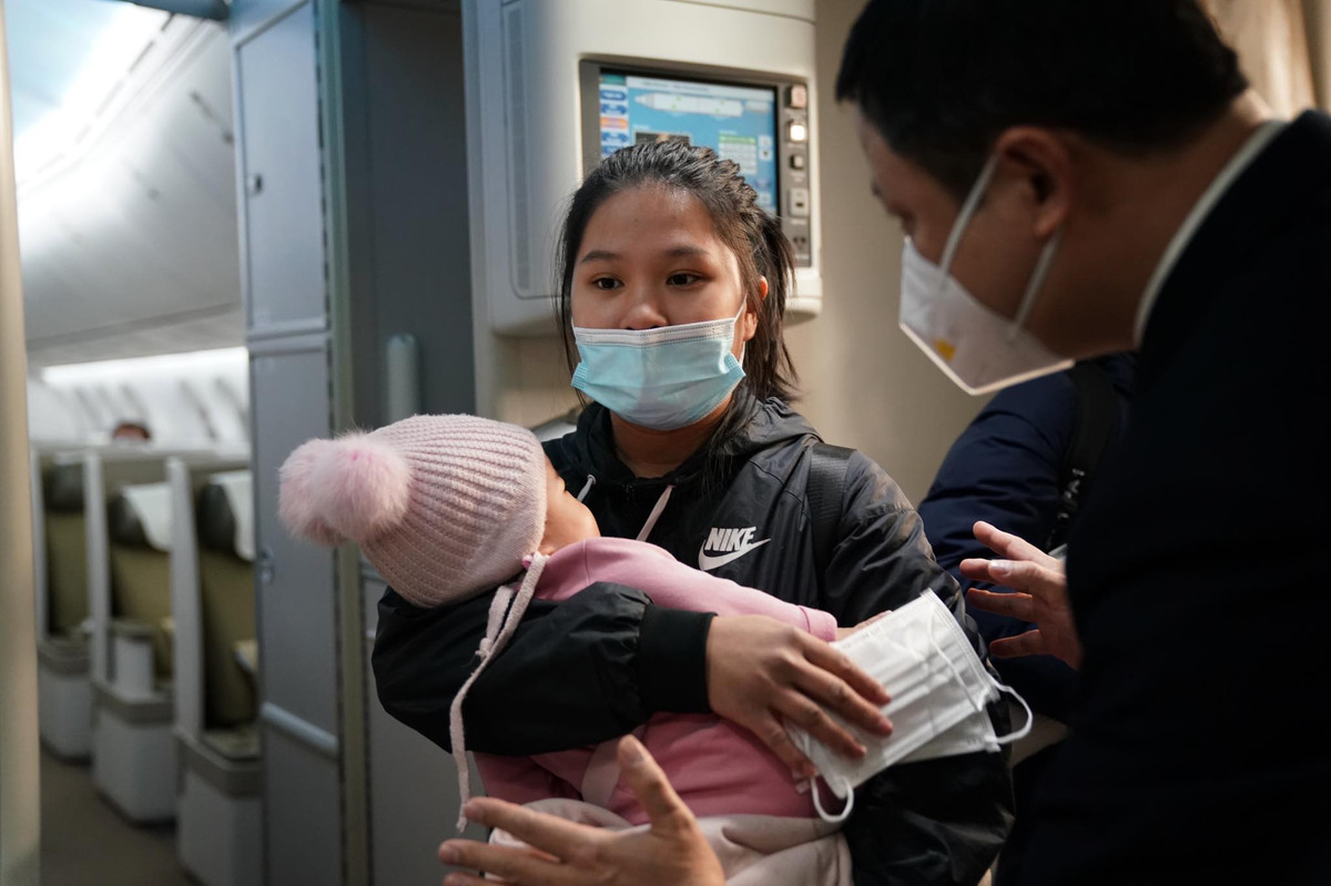 Tiếp viên Vietnam Airlines hướng dẫn hành khách vào đúng số ghế trên chuyến bay về nước.