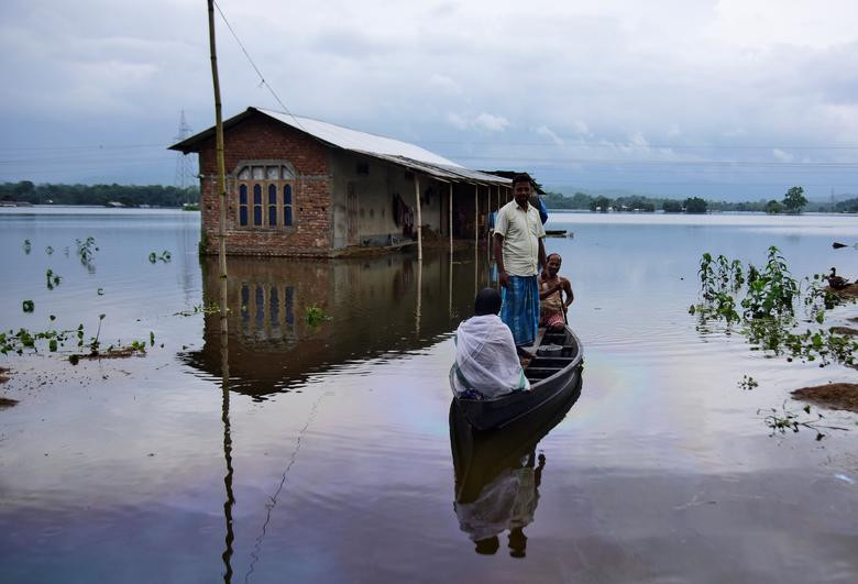 Người dân dùng thuyền di chuyển trong ngôi làng ở Nagaon, bang Assam, Ấn Độ, ngày 15/7.