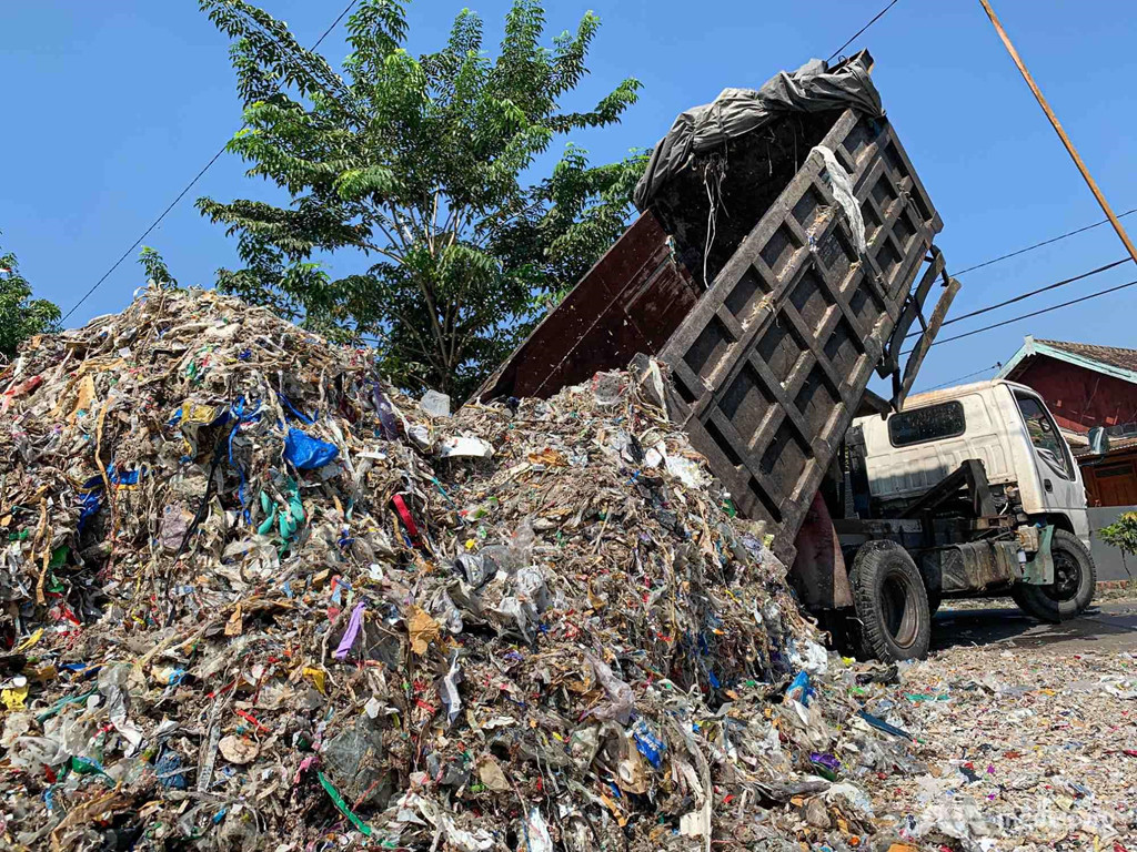 Cũng như nhiều gia đình tại Bangun, Supriadi trả tiền để xe tải chở những lô rác mới tới khu đất nhà mình mỗi tuần. Từ đống rác tưởng như vô giá trị, người đàn ông này có thể thu lại gấp đôi số tiền bỏ ra sau khi phân loại những vật dụng giá trị cao như vỏ kim loại và dây cáp. Những thứ khác có thể được bán cho nhà máy đậu phụ địa phương, nơi sử dụng rác thải nhựa để đốt làm nhiên liệu. Ảnh: CNA.