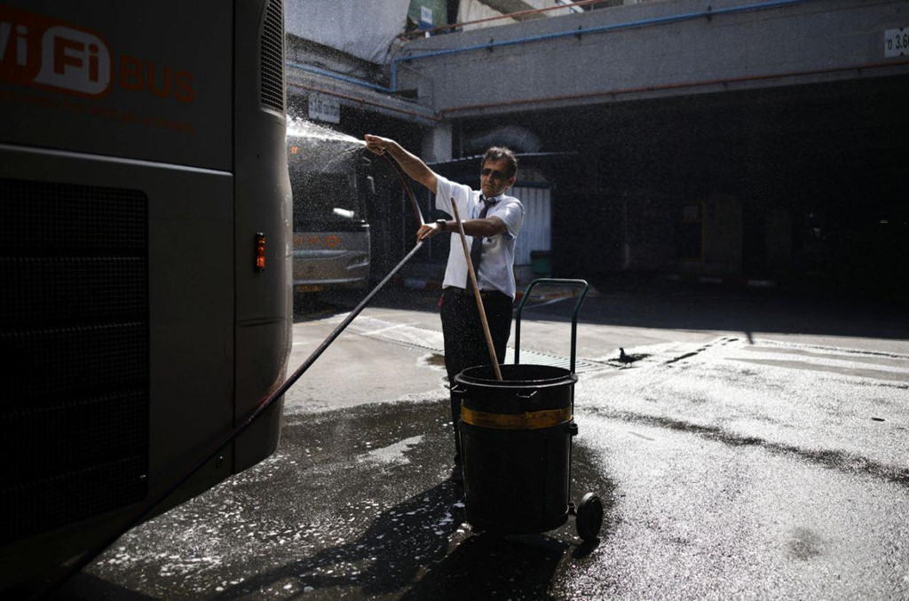 Một tài xế rửa xe buýt tại Trạm xe buýt Trung tâm.