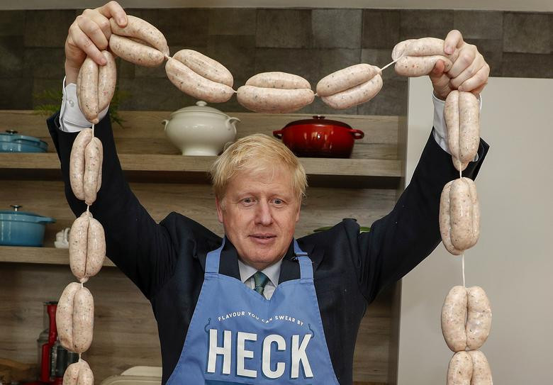 Cựu Ngoại trưởng Anh Boris Johnson cầm một dây xúc xích khi tới thăm công ty Heck Foods trong chiến dịch vận đông tranh cử gần Bedale ngày 4/7.