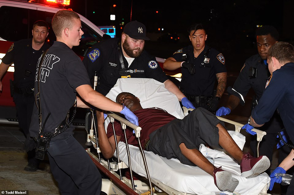 Một người đàn ông bị thương trong vụ xả súng hàng loạt được đưa đi bệnh viện. 