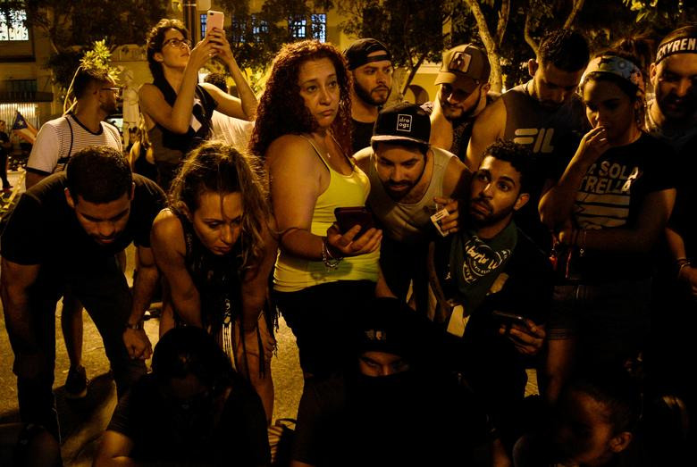 Những người biểu tình nghe đoạn video thông báo từ chức của Thống đốc Ricardo ngày 24/7.